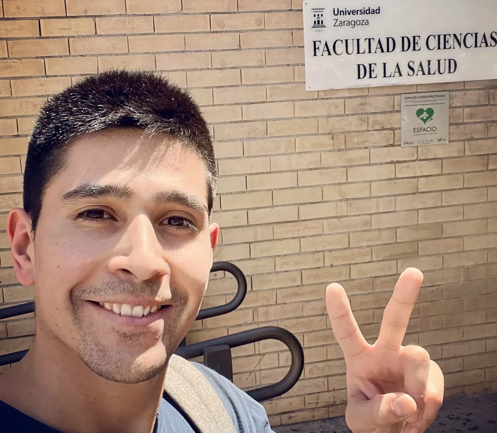 Diego Gálvez frente al rótulo de la Facultad de Ciencias de la Salud de la Universidad de Zaragoza.