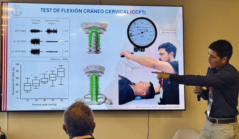 Diego Gálvez exponiendo frente a una pantalla con el test de flexión craneocervical.